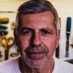 Portrait of a senior man with tools in the background, exuding confidence.